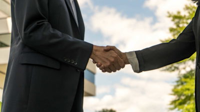 Two businesspeople shaking hands - Contact Us | Amarex